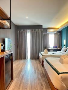 ein Hotelzimmer mit 2 Betten und einem TV in der Unterkunft The Bed's 304 