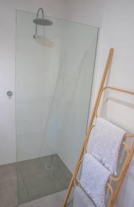 a shower with a glass door and a towel rack at Barkly Beach House Warrnambool in Warrnambool