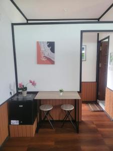einen Schreibtisch in einem Zimmer mit 2 Hockern und einem Spiegel in der Unterkunft Fisheries VIP in Derawan Islands
