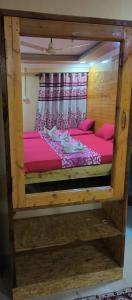 a wooden bunk bed with pink sheets in a room at ALEGRO HOLIDAY HOMES in Palolem
