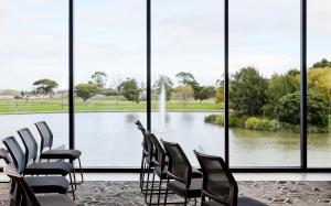 a room with chairs and a view of a lake at Punthill Caroline Springs in Caroline Springs