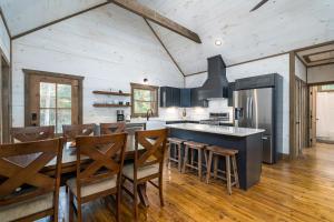 a kitchen with a table and chairs and a refrigerator at Peaceful Luxury Cabin, hot tub, games, 3 fireplaces in Blue Ridge