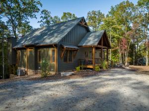 a small green house with a gambrel roof at Peaceful Luxury Cabin, hot tub, games, 3 fireplaces in Blue Ridge
