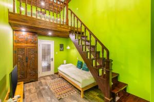 a green room with a staircase and a bed at Beijing Shixi Inn - Wangfujing Nanluoguxiang Branch in Beijing