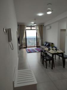 TranquerahにあるThe Quartz 3 Bedroom Apartment with fully furnish and fully aircond, infinity pool, Corner lot with seaview and city view centre of malacca cityのリビングルーム(テーブル、ソファ付)