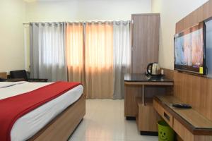 a hotel room with a bed and a flat screen tv at HOTEL PRITAM PARK in Jālgaon