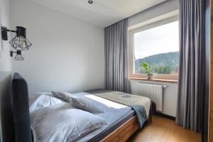 a bedroom with a bed and a large window at Wilcze Zacisze in Ustrzyki Dolne