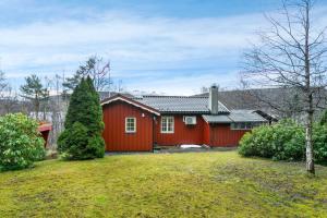 una casa roja con un patio delante en Fjord peace en Skodje