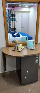 einen Schreibtisch mit einem Spiegel und ein Bett in einem Zimmer in der Unterkunft ALEGRO HOLIDAY HOMES in Palolem
