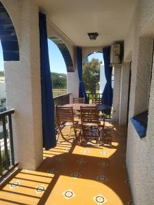 eine Terrasse mit Tischen und Stühlen auf dem Balkon in der Unterkunft Apartamento, 3° línea de playa in Cubelles