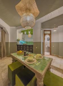 una sala da pranzo con tavolo e lampadario pendente di Maison Maria Palmeraie a Marrakech