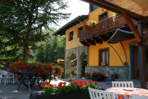 a house with a table and chairs and red flowers at La Maison Du Bon Megnadzo in Doues