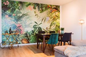 a dining room with a mural of plants at Dschungel in BaLi 72qm Ferienwohnung im Zentrum in Bad Lippspringe