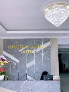 a chandelier and a hotel sign in a lobby at Sai Gon Ha Tien Hotel in Hà Tiên