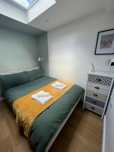 Central ensuite guest unit with free on-street parking في برايتون أند هوف: غرفة نوم عليها سرير وفوط