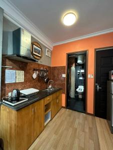eine Küche mit orangefarbenen Wänden, Holzschränken und einer Spüle in der Unterkunft Elegant Studio Yet Kieu in Hanoi