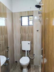 y baño con aseo y lavamanos. en Khoai Village Resort en Shānti Niketan