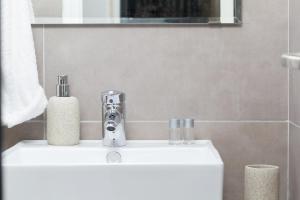 ein Waschbecken im Badezimmer mit einem Seifenspender in der Unterkunft Agerino in Moutsoúna + 76 Fotos