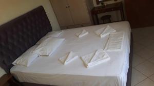 a white bed with white pillows on it at Pela Apartments in Sisi