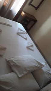 a bed with white sheets and pillows in a room at Pela Apartments in Sisi