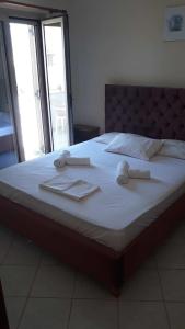 a large bed with white sheets and towels on it at Pela Apartments in Sisi