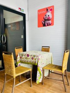 a table with chairs and a table with a pink pig on it at Rabbitel Phuket in Phuket