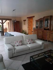 a living room with a white couch and a bed at La maison d'Augusta in Saint-Martin-de-Coux