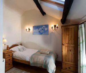 um quarto com uma cama e um armário de madeira em River Cottage Brecon: Hot Tub, Fire, Balcony, Wifi em Brecon