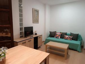 sala de estar con sofá y TV en At Home Realejo, en Granada