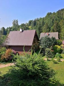 a house in the middle of a yard with trees at Osada Bura Polana in Ujsoły