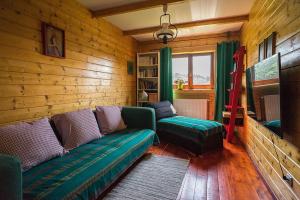 a living room with a couch and chairs in a room at Osada Bura Polana in Ujsoły