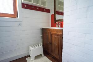 a small bathroom with a sink and a stool at Osada Bura Polana in Ujsoły