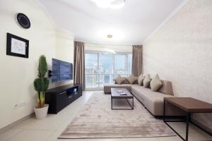 uma sala de estar com um sofá e uma televisão em SHH - Furnished 1BR Apartment in Goldcrest Executive, Jumeirah Lake Towers em Dubai