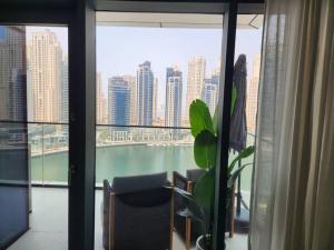 Cette chambre dispose d'une grande fenêtre offrant une vue sur la ville. dans l'établissement Vida Dubai Marina & Yacht Club, 1 BR with Marina and Sea View, à Dubaï