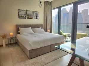 a bedroom with a large bed and a glass table at Vida Dubai Marina & Yacht Club, 1 BR with Marina and Sea View in Dubai