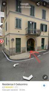 a building with a red arrow in a parking lot at Residenza il Gelsomino in Cantello