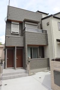 a house with two garage doors in front of it at パルティール矢向１０１号室 in Yokohama