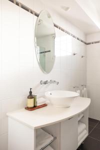 a white bathroom with a sink and a mirror at Peppers Seaport Hotel in Launceston