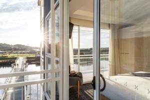 a bedroom with a balcony with a view of the water at Peppers Seaport Hotel in Launceston