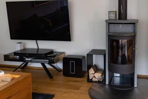 a living room with a fireplace and a tv at Wohnung Pulverturm in Appenzell