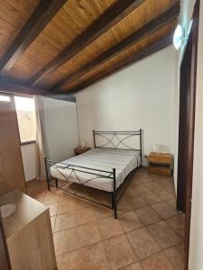 Schlafzimmer mit einem Bett mit Holzdecke in der Unterkunft Ciclamino in Alcamo Marina