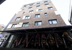 首爾的住宿－Itaewon A One Hotel，商店顶部有窗户的高高的砖砌建筑
