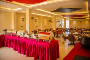 a restaurant with red tables and chairs in a room at Dreamland Hotel in Arua