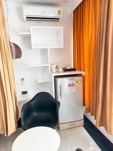 a room with a black chair and a refrigerator at The Color Kata in Kata Beach