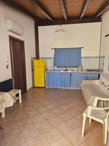 ein Wohnzimmer mit einem Sofa und einer Küche in der Unterkunft Ciclamino in Alcamo Marina