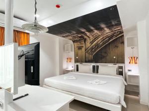 a bedroom with a white bed and a painting on the wall at The Color Kata in Kata Beach
