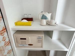 a microwave on a shelf in a kitchen at The Color Kata in Kata Beach