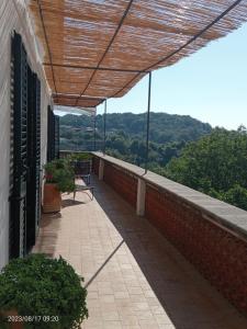 a balcony with a bench and a view of the mountains at Radici Dimora natura cultura in Campagnola
