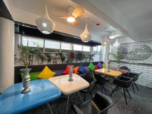 a restaurant with tables and chairs with colorful cushions at The Color Kata in Kata Beach