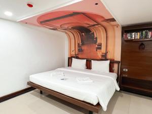 a bedroom with a bed with a painting on the wall at The Color Kata in Kata Beach